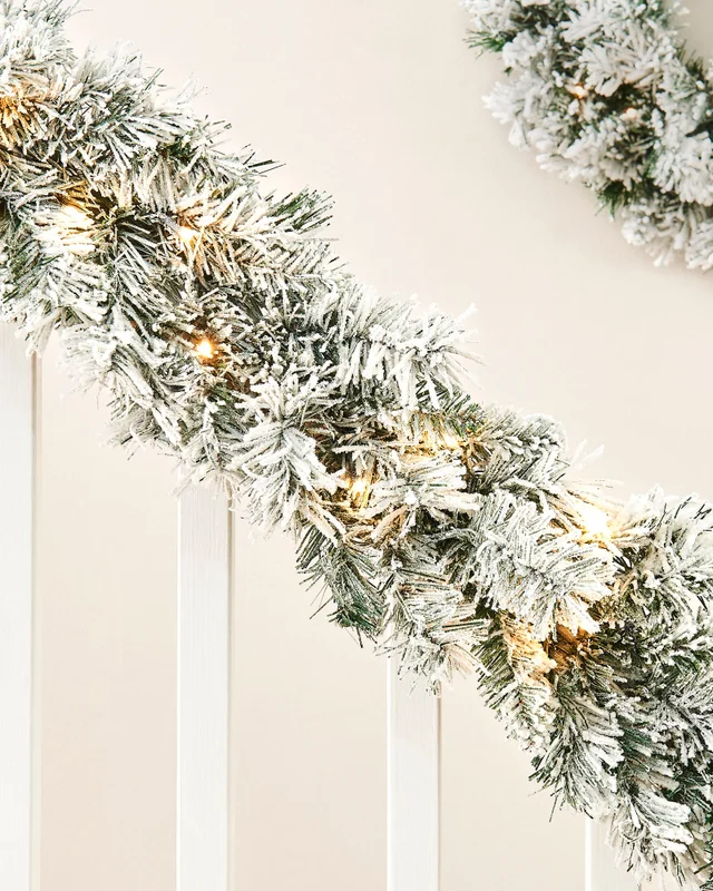 WeRChristmas Green And White Pre-Lit Snow-Flocked Spruce Artificial Christmas Garland 20 Warm White Leds 9 Ft
