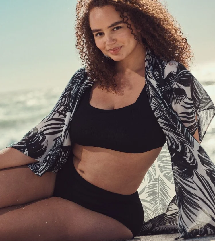 Woman wearing lightweight shirt as a beach cover up over bikini